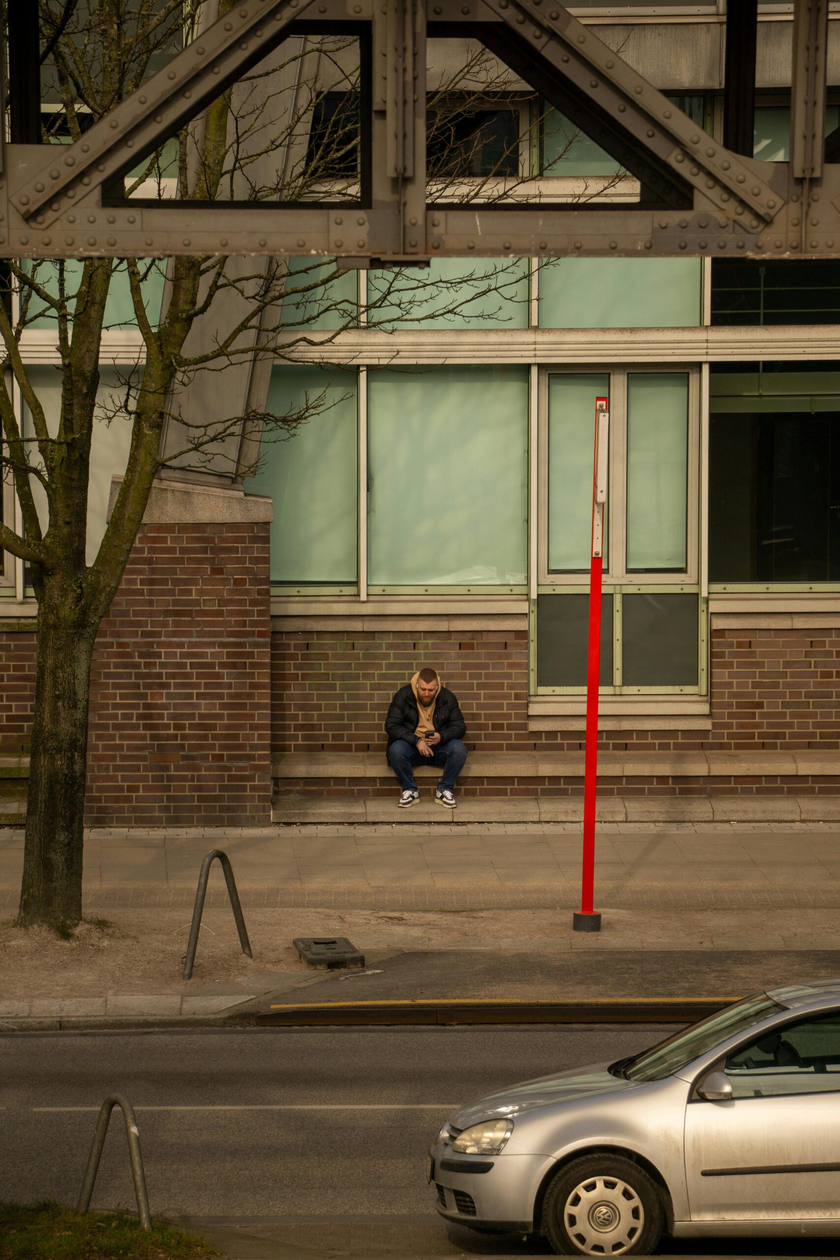 A person sitting outside a building in Hamburg, Germany, reflecting an urban lifestyle.